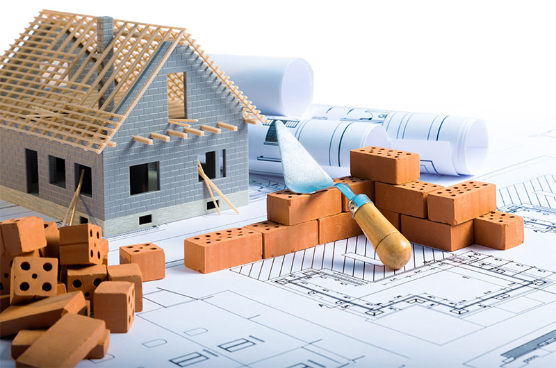 Building plan with model house and bricks