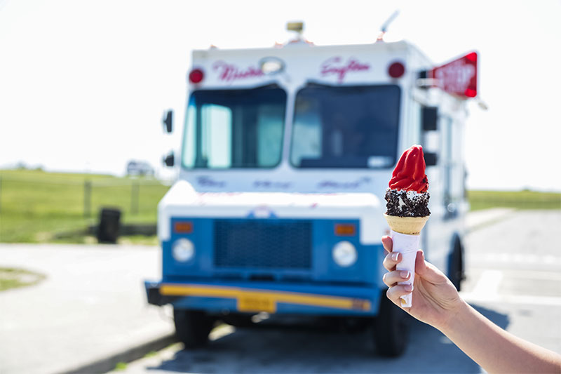 Ice cream truck with customer holding ice cream cone