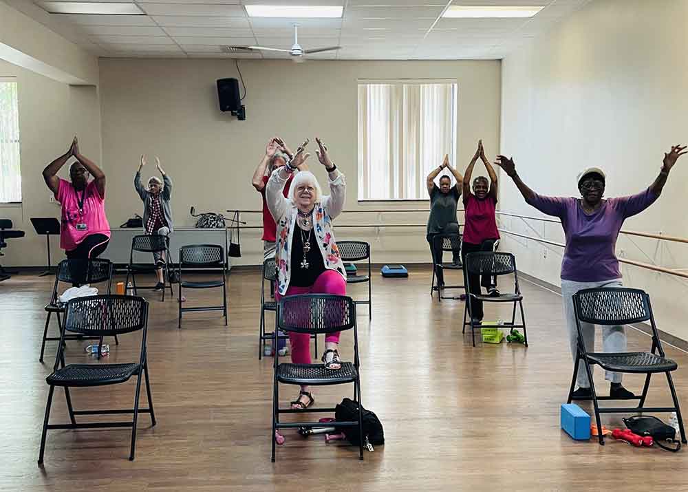 50 and beyond seniors in chair yoga class