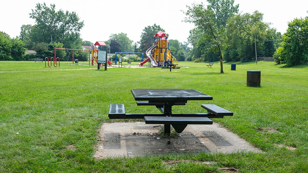 Rambling Road Park picnic table with playground in the distance